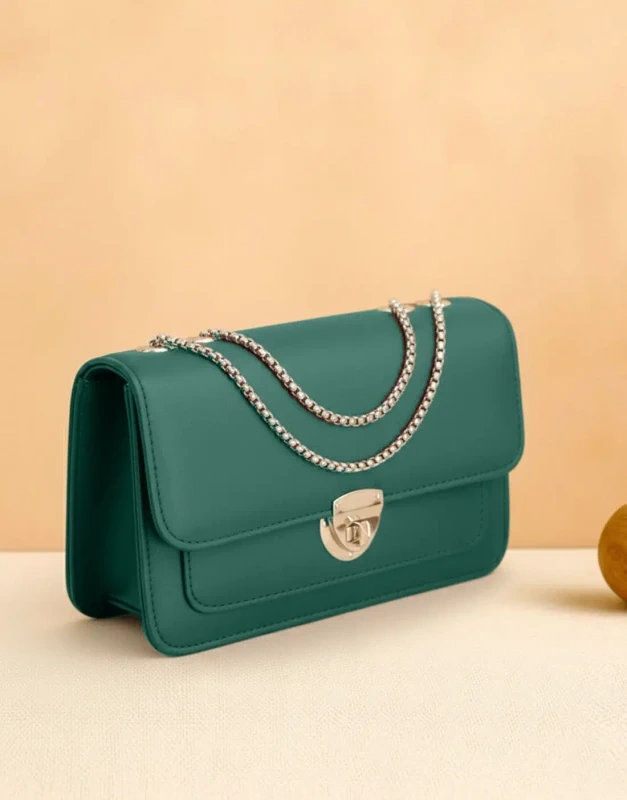Emerald-green PU-leather crossbody bag with gold twist-lock and chain strap, studio product shot