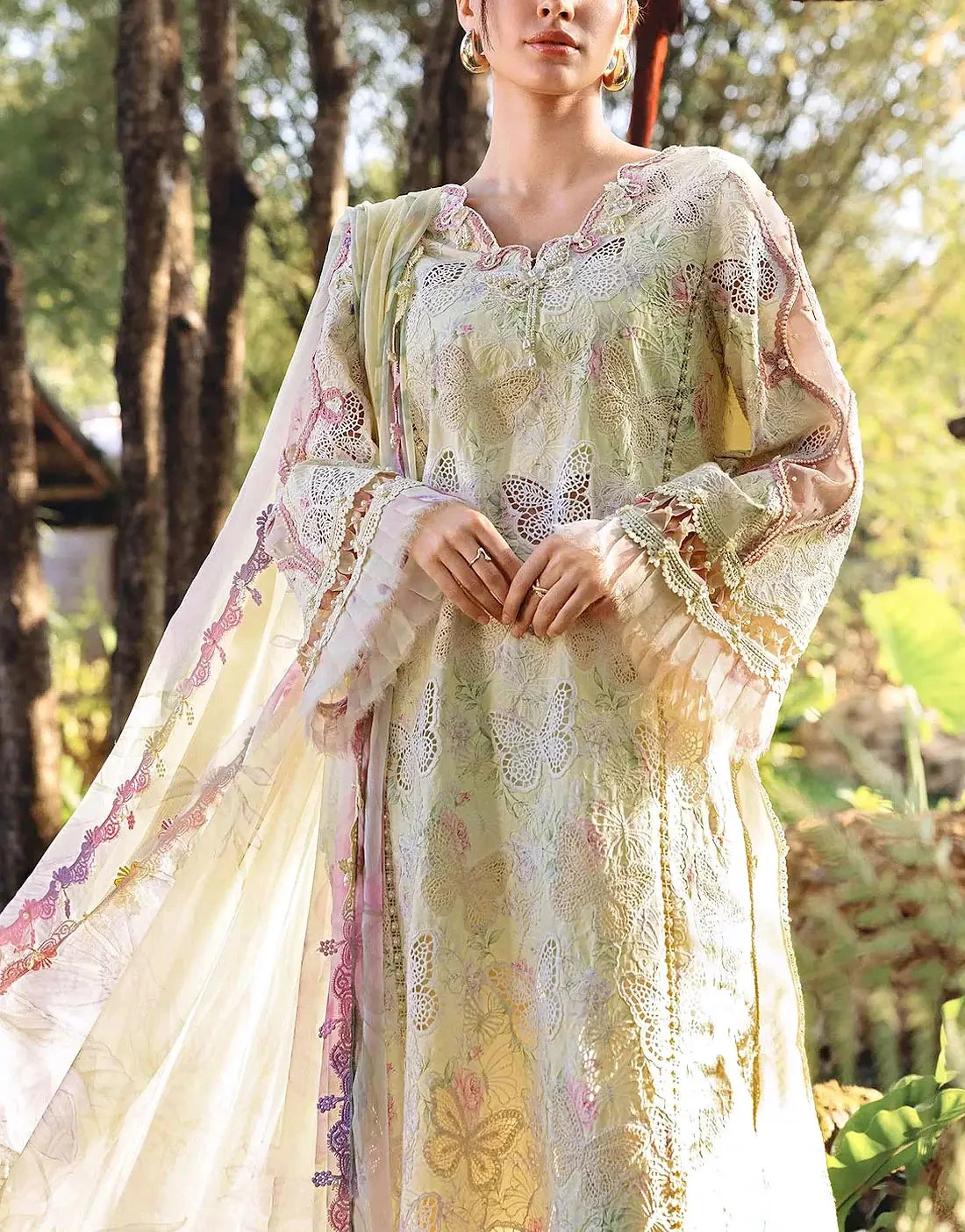 Model in a pastel lawn kurta with floral cutwork and a sheer embroidered dupatta, photographed outdoors in soft daylight